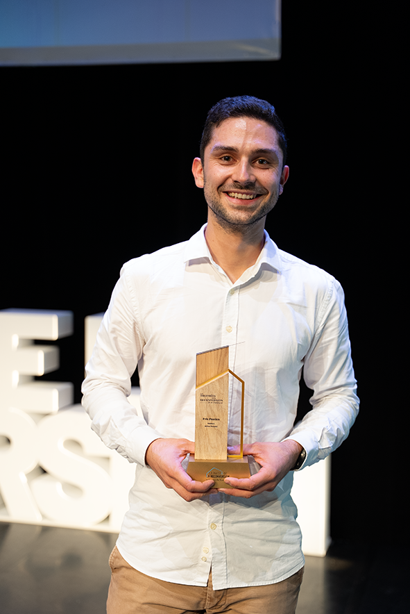 Arthur Dumard sur scène, tenant son trophée