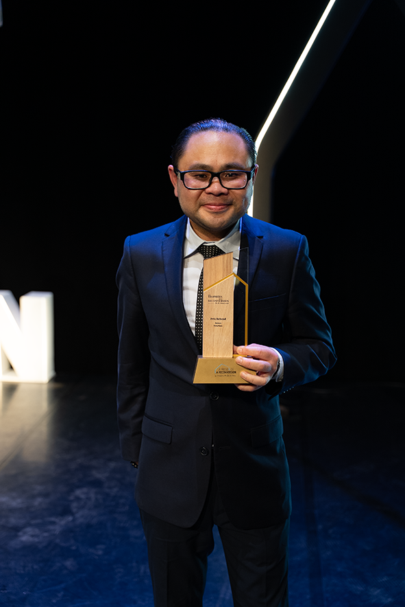 Hong Ngau sur scène, tenant son trophée