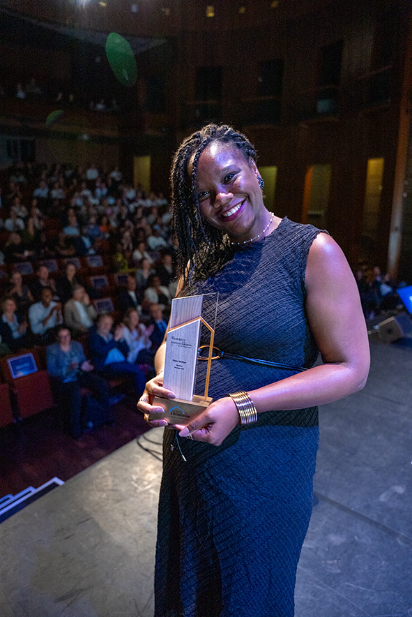 Monique Sall sur scène, tenant son trophée